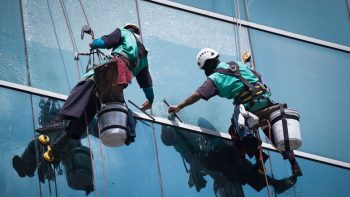 an insured window cleaning service's employees cleaning high rise windows
