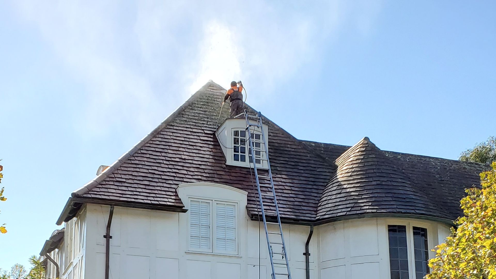 a professional man soft washing a roof in San Francisco