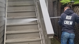 an ASF Clean Team crew member using the hot power washing technique