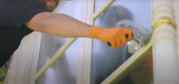 expert window cleaner washing with a window cleaning solution