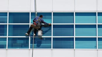 a professional cleaning a high rise window