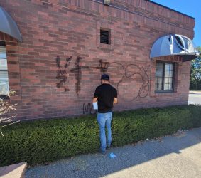ASF Clean Team member performing graffiti removal on a building