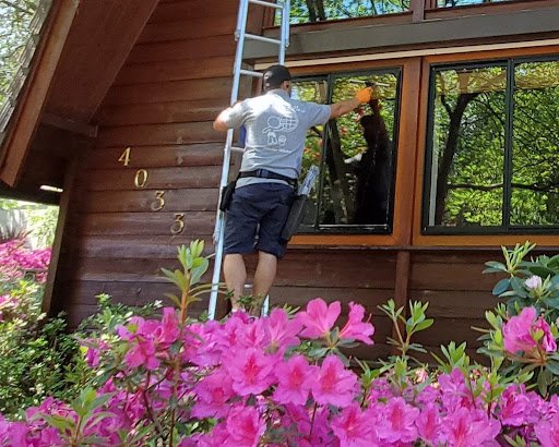 man on ladder cleaning windows
