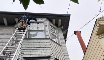 Windows are getting cleaned on a tall home.